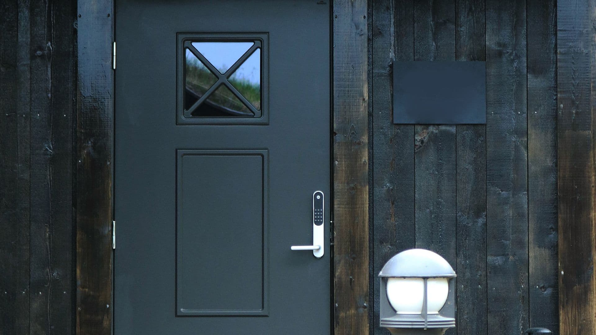 Sort hyttedør med glass.