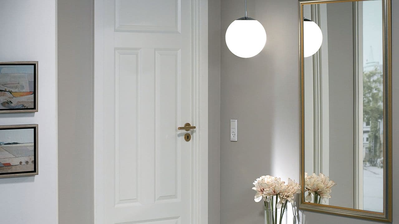 Hvit profilert kompakt innerdør med gullfarget dørvrider.