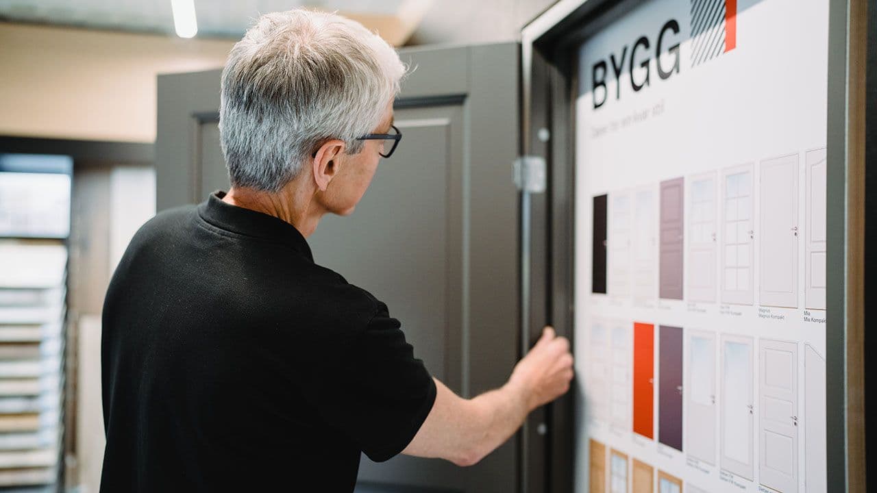 Ansatt hos Byggtorget Mysen som viser dør.
