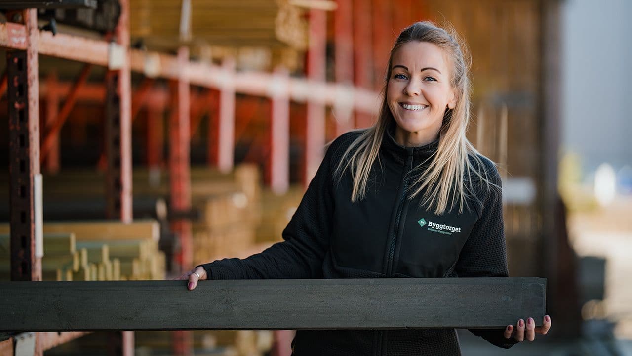 Julie Flaa Sundsdaal ved Byggtorget Birkenes holder frem mørkt terrassebord.