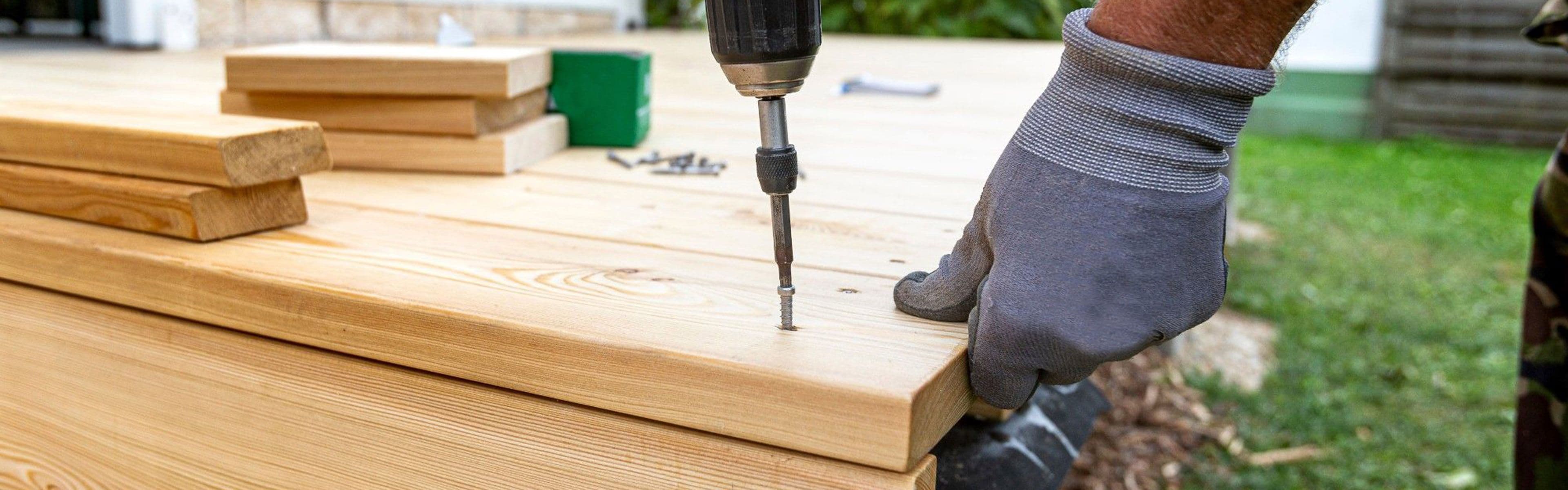 Person som bygger terrasse med drill.