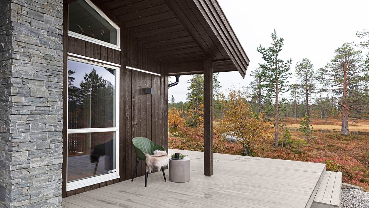 Hytte og terrasse malt med utebeis JOTUN TREBITT Oljebeis; Vegg:TREBITT 9052 Eksotisk tre, Detaljer: Jotun 1453 Bomull, Terrasse: TREBITT Terrassebeis 9073 Shimmergrå.