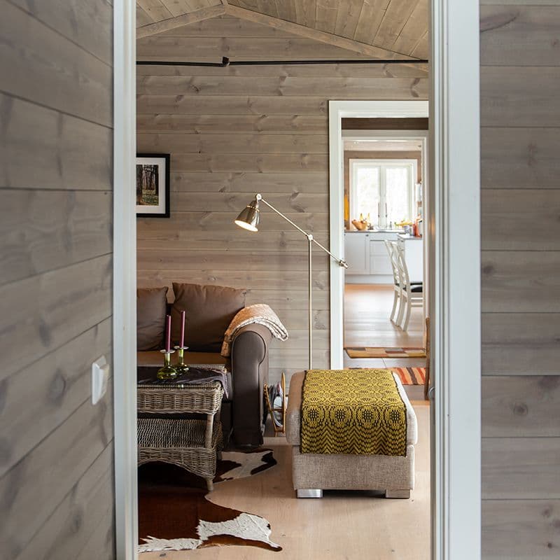 Oppholdsrom i hytte med trepanel i fargen Setergrå.