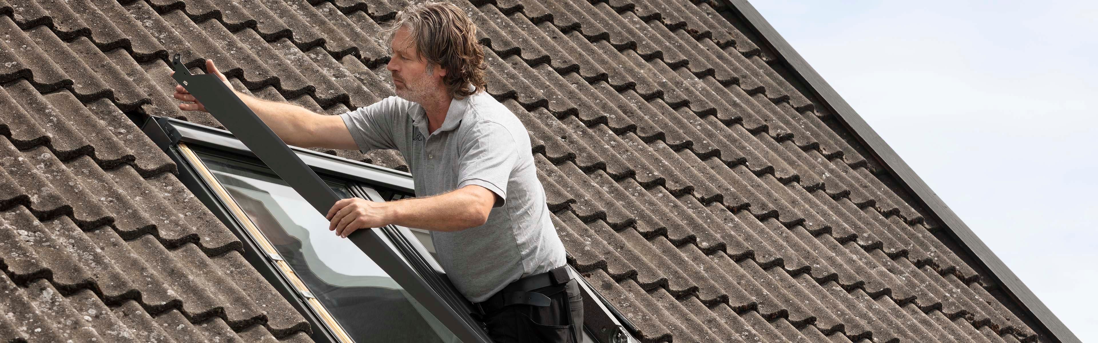 Person som monterer utvendig solskjerming på takvindu.