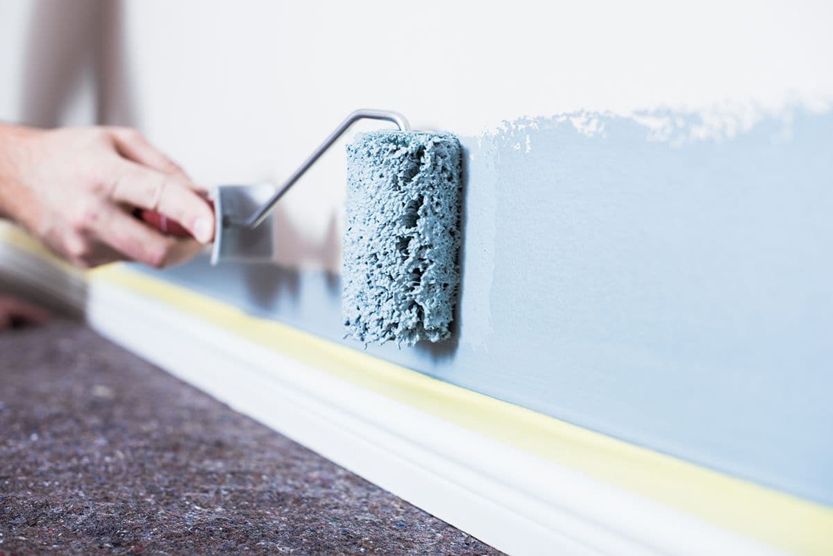 En vegg inne males lyseblå med rulle fra Jordan