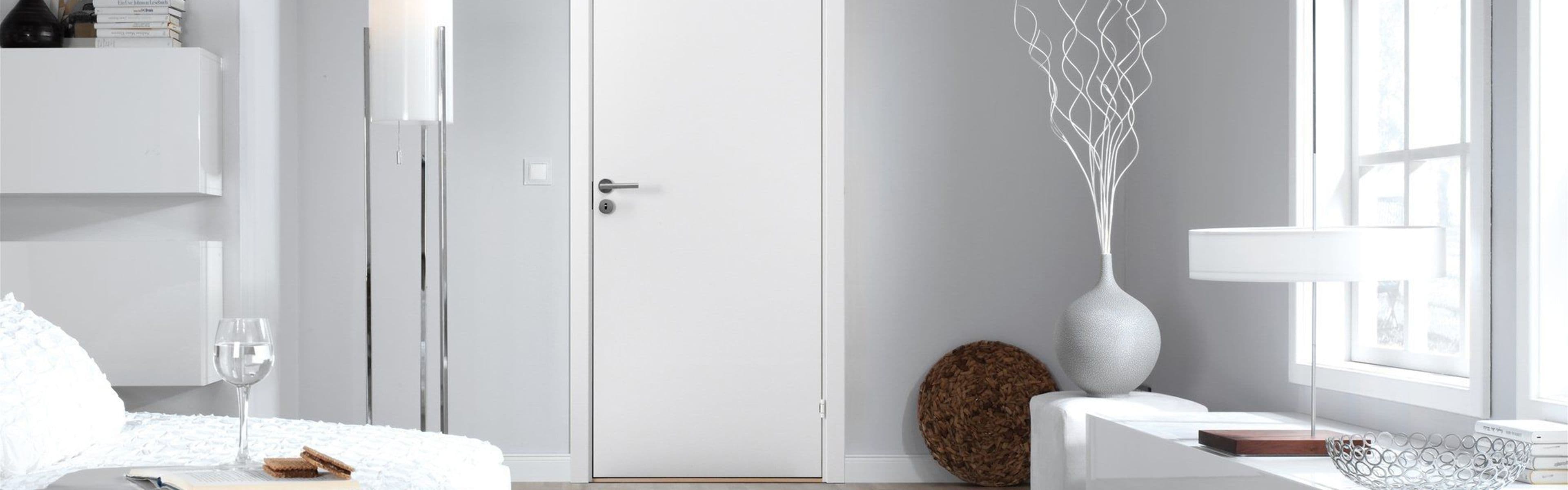 Hvit slett dør inne i lys stue.