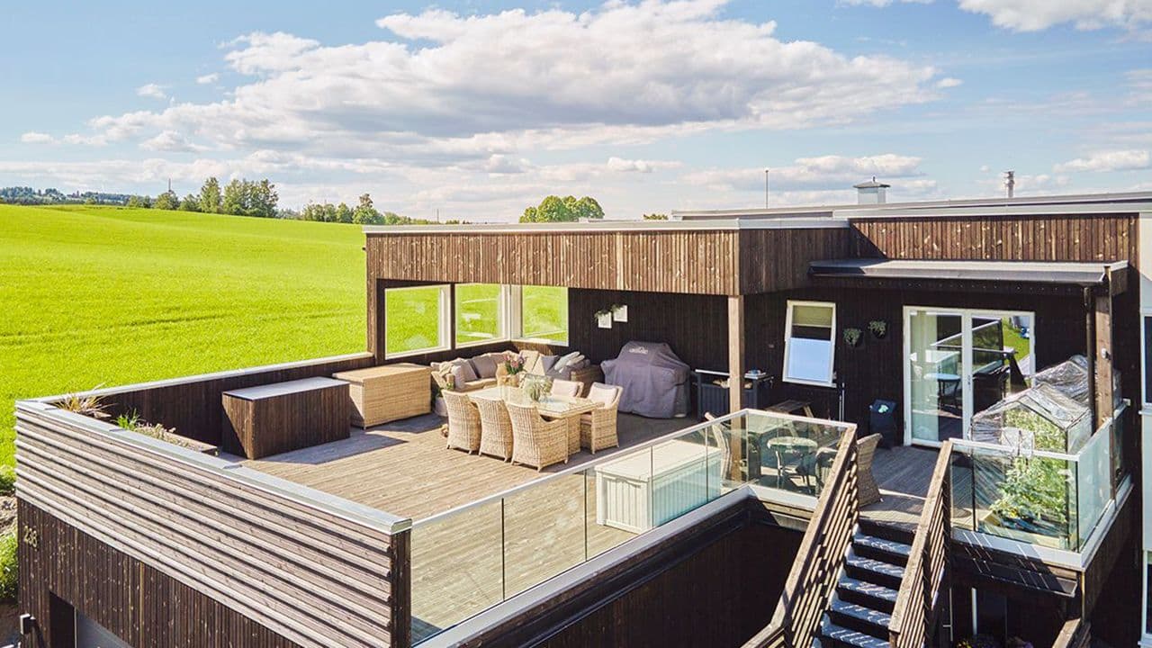 Takterrasse på funkishus i sommersol.