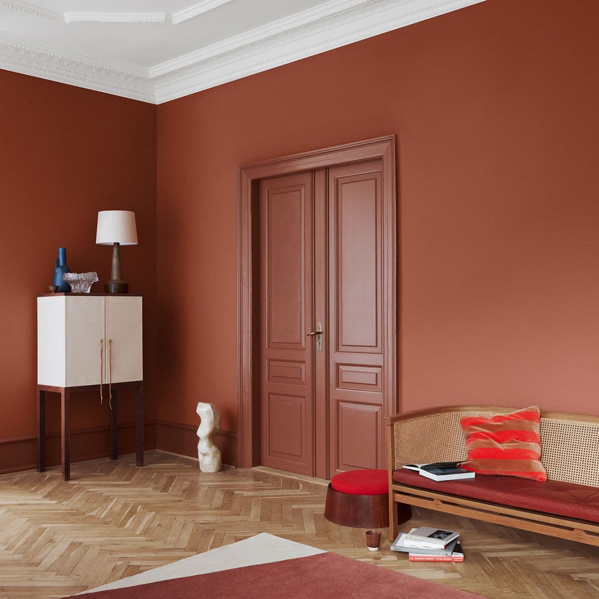 stor stue der både vegg og dør er malt i fargen Lively Red fra Jotun, men i ulik glansgrad.