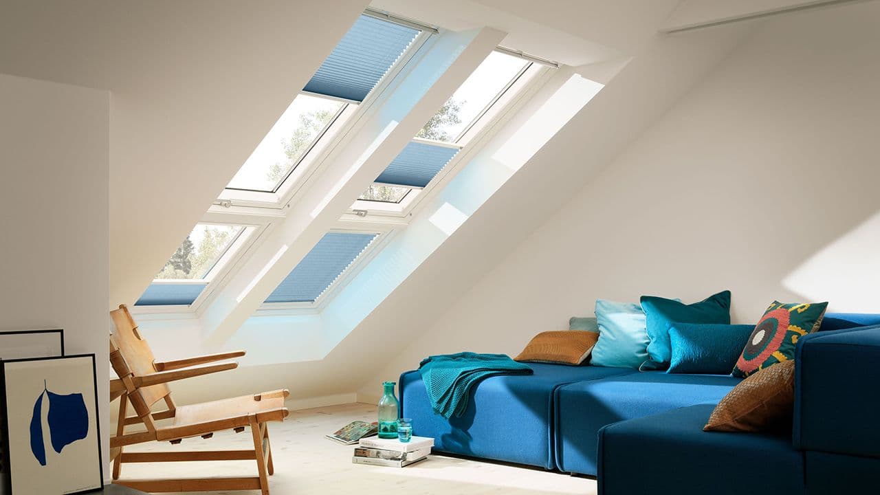 Stue med sofa og mange takvinduer med innvendig solskjerming.