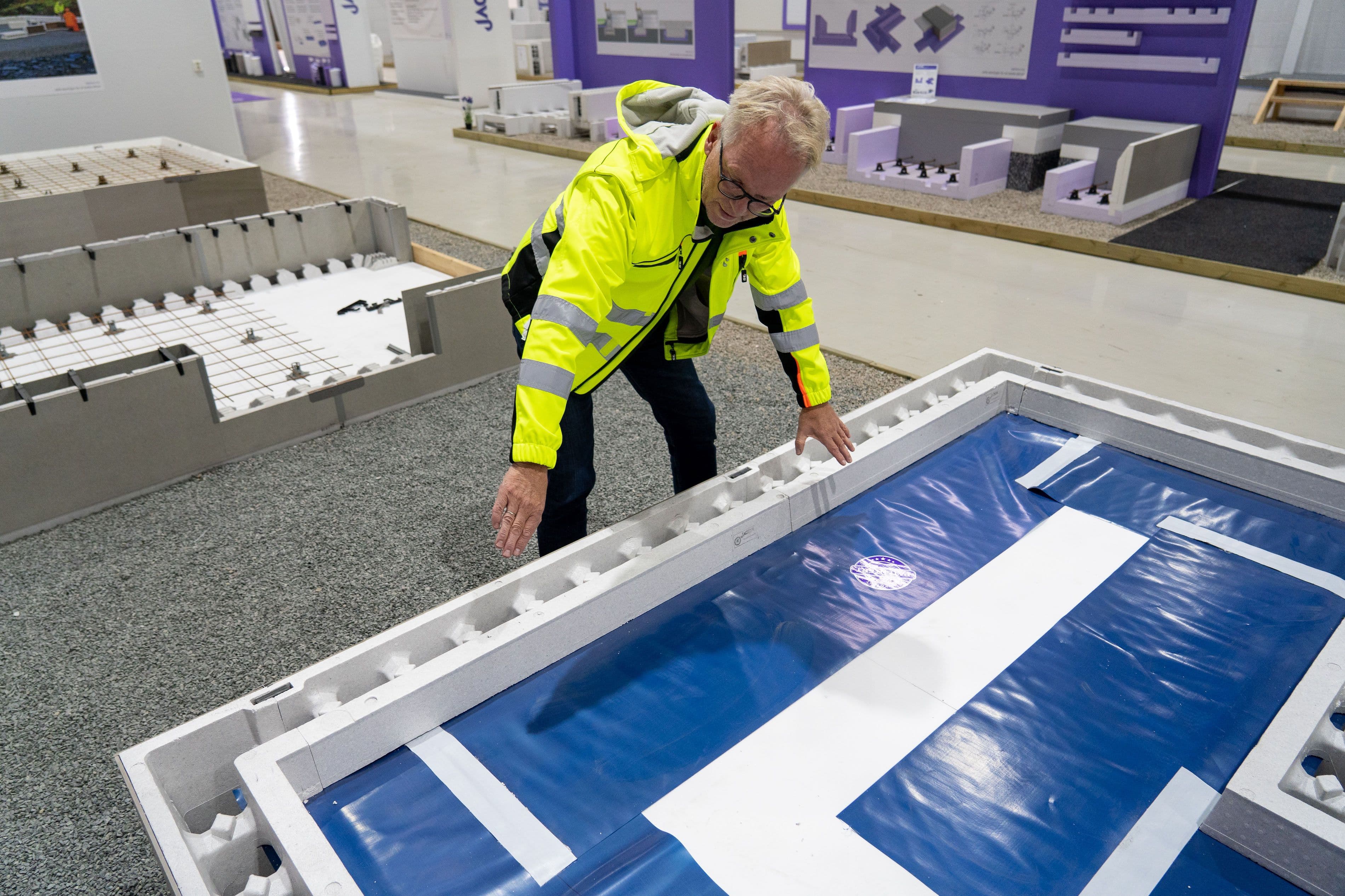 Mann i gul jakke som viser frem Jackon Ringmur RA.