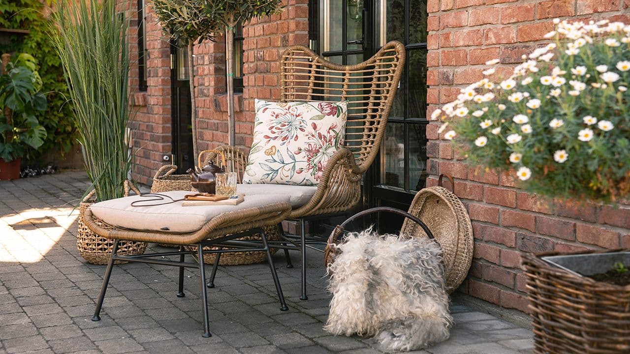 Aaltvedt belegningsstein utenfor murhus med sittegruppe.