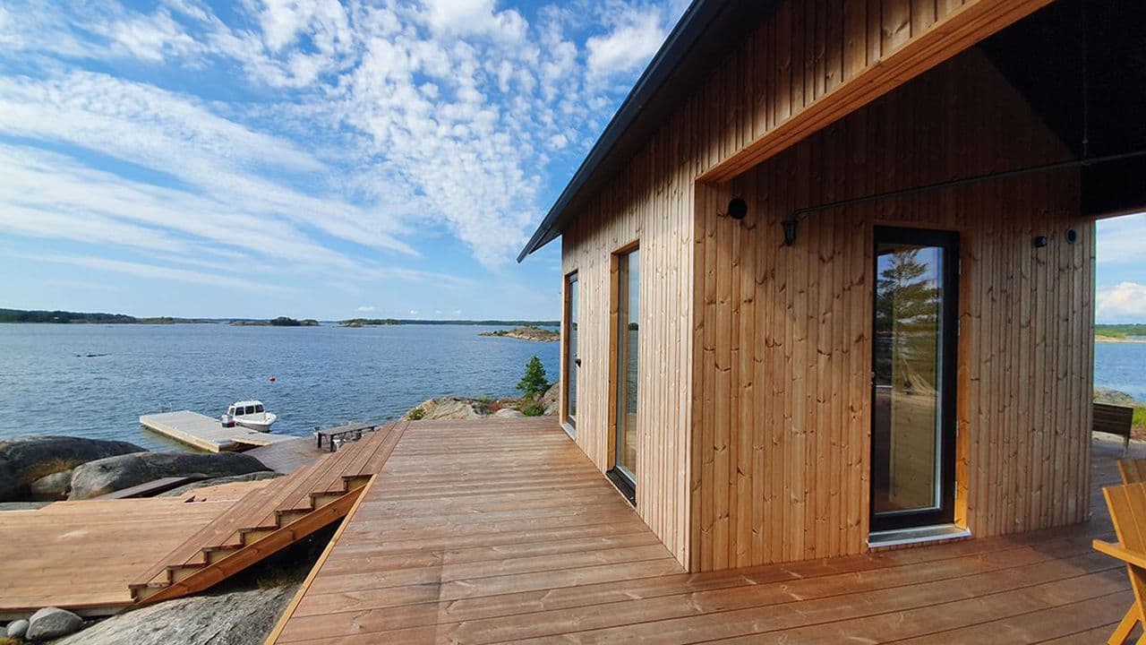 Moderne hus i havgapet med brygge og moderne utvendig kledning av termofuru.