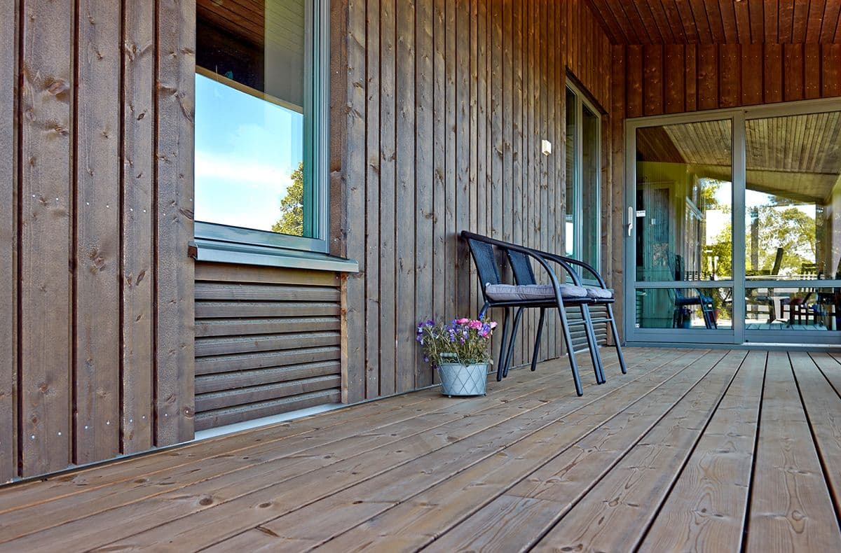 Hus med termofuru kledning og terrassebord.
