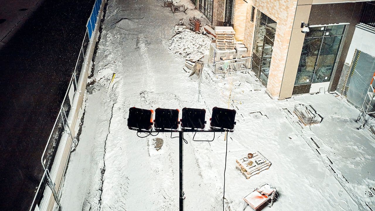 Arbeidslamper på stativ som lyser opp byggeplass utendørs.