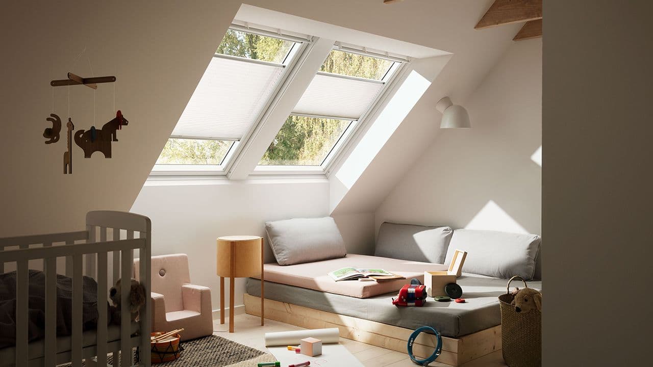 Barnerom på loftet med to vinduer med solskjerming.