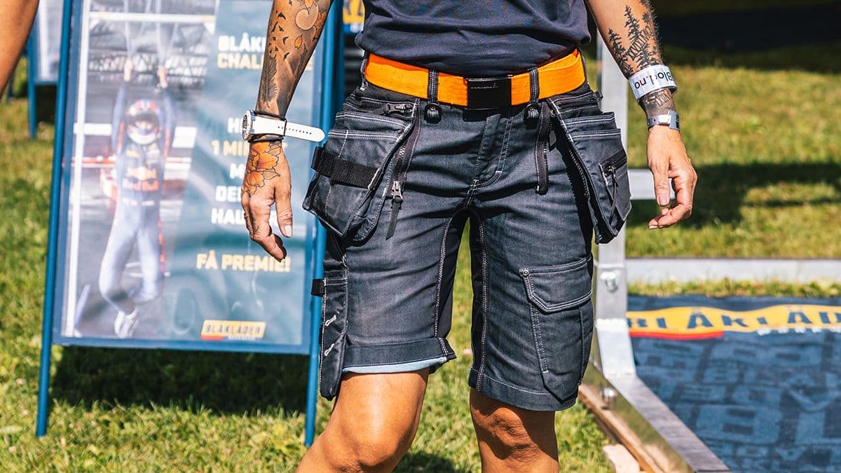 kvinnelig, tatovert håndverker i arbeidsshorts