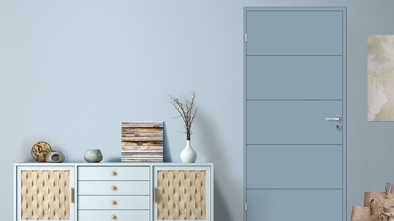 Moderne stue med blå vegg og innerdør fra Bygg1 i samme farge som veggen.