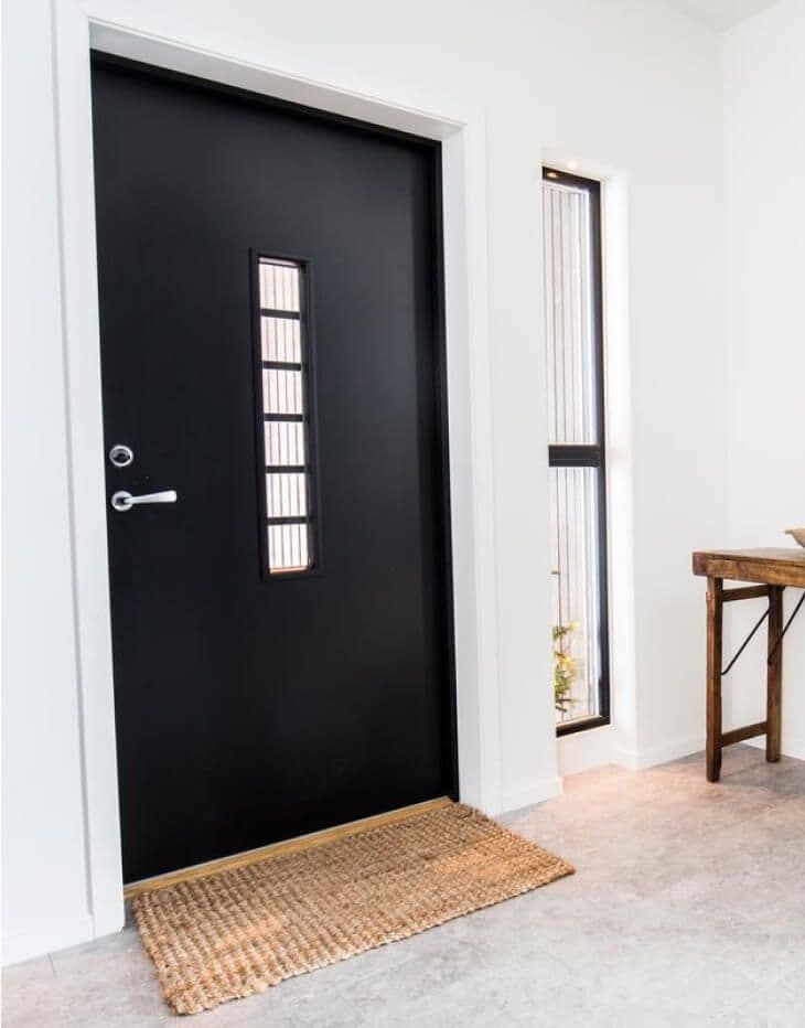Svart ytterdør med glassfelt.