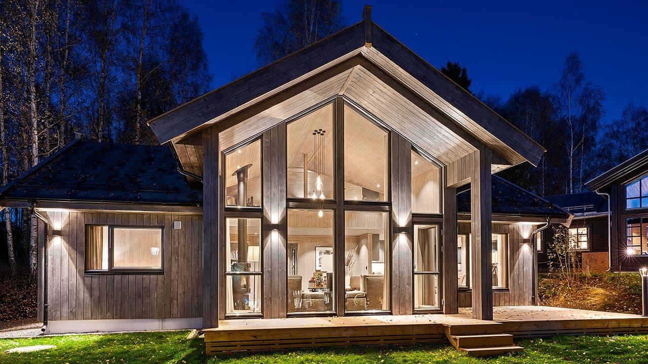 Hytte med store, nye vinduer sett utenfra.